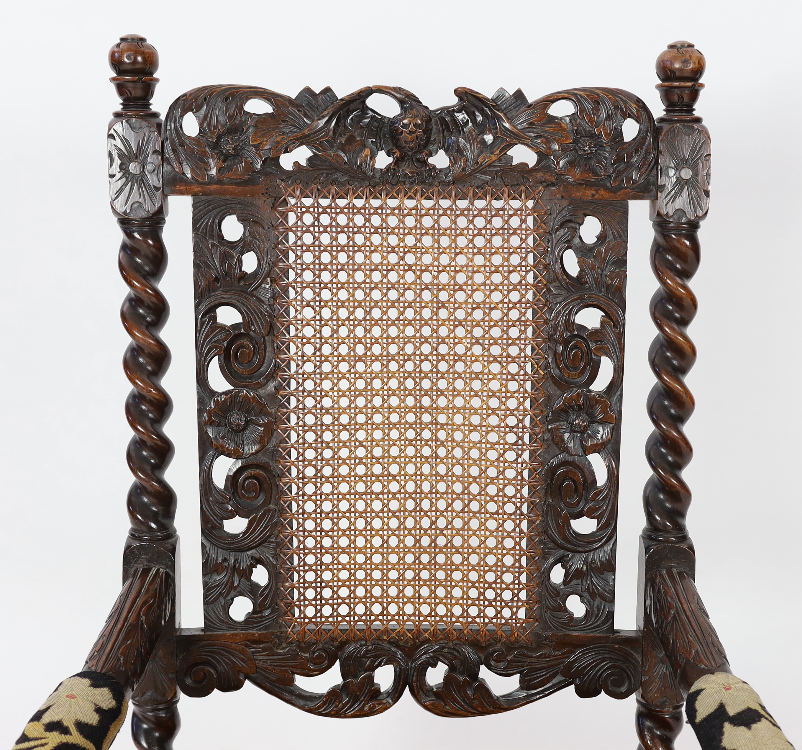 A Charles II carved walnut caned back elbow chair, with a contemporary needlework upholstered seat, c.1670, width 63cm, height 116cm, Please note this lot attracts an additional import tax of 5% on the hammer price